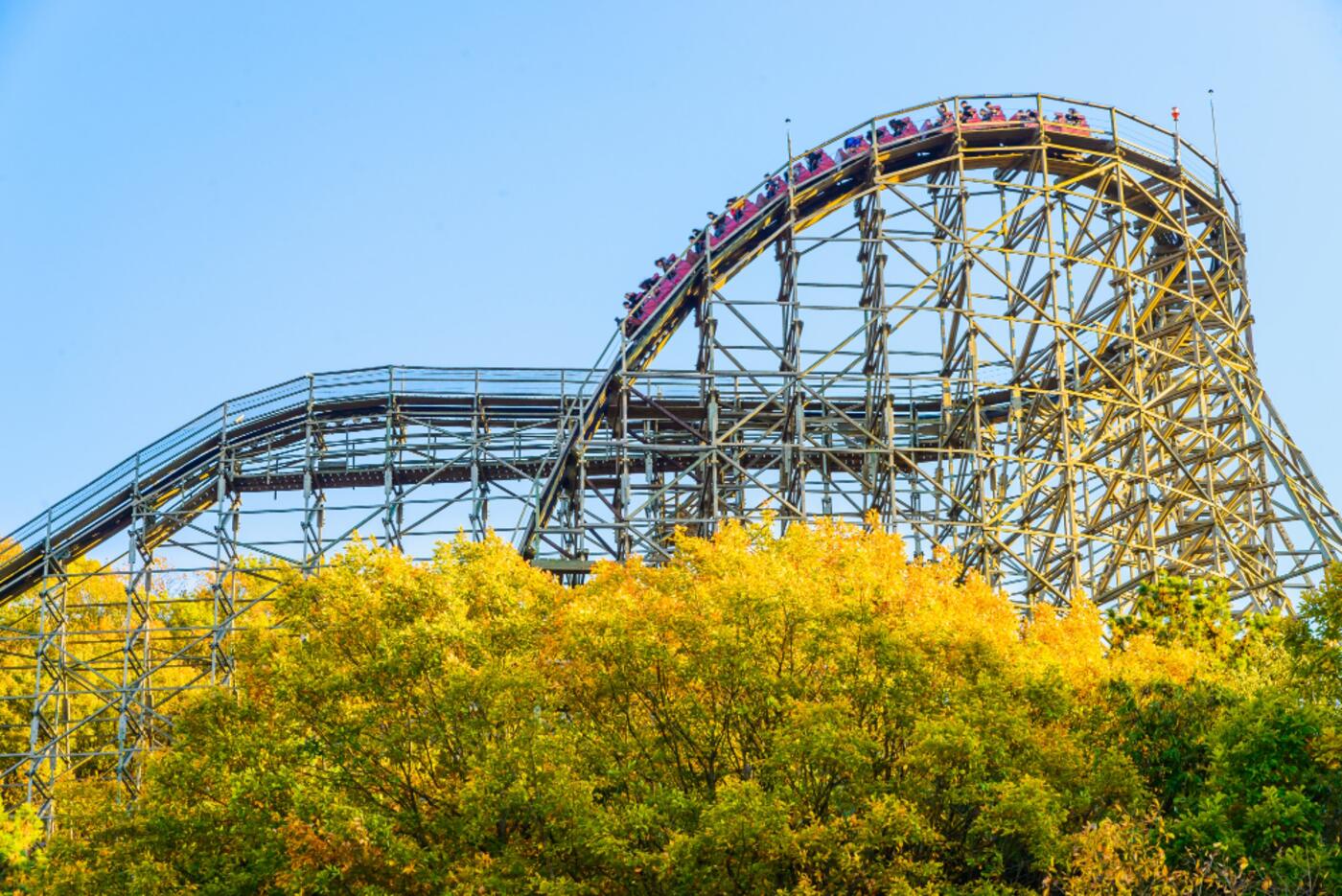 A theme park midway with a Butlaroo self-order kiosk beside a food outlet.