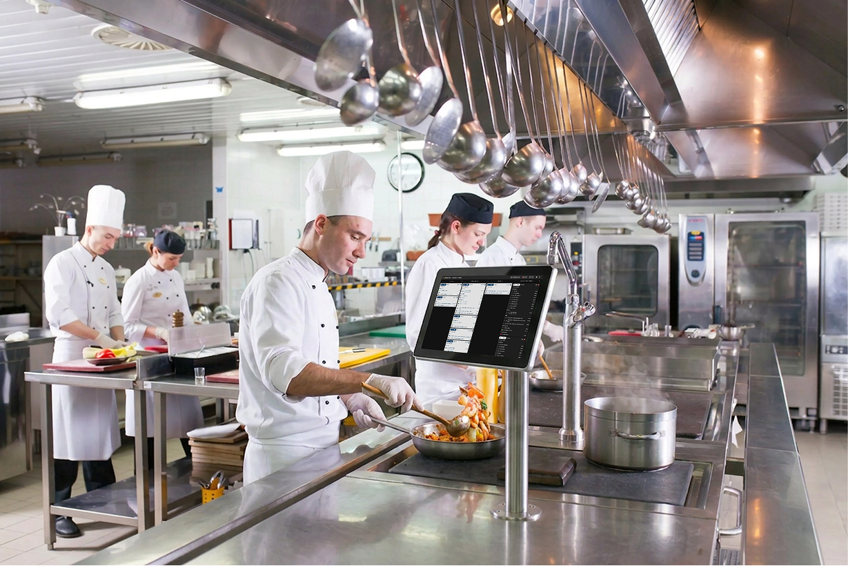 Chef plating a dish next to a Butlaroo Workstation kitchen display.